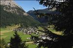 View through the trees towards the village of La Punt Chamues-ch